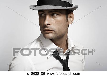 Stock Photograph - Mid adult man wearing fedora. Fotosearch
