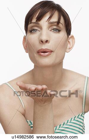 Mid adult woman blowing air kiss View Large Photo Image Stock Photograph - Mid adult woman blowing air kiss. Fotosearch