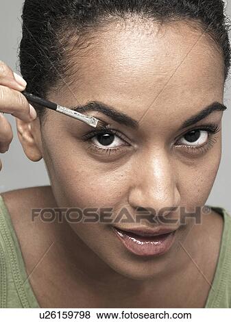 Young woman applying eye shadow View Large Photo Image Stock Photo - Young woman applying eye shadow. Fotosearch