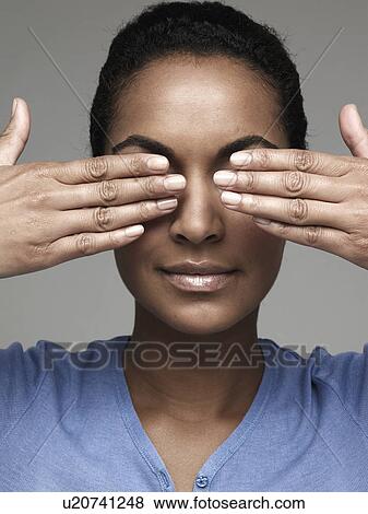 Stock Photo - Young woman covering eyes with hands. Fotosearch