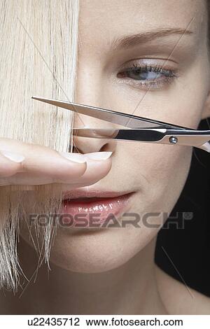 Young woman cutting her hair, close-up View Large Photo Image Stock Image - Young woman cutting her hair, close-up. Fotosearch