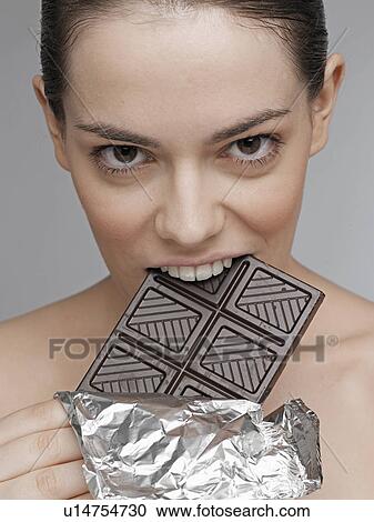 Young woman eating dark chocolate View Large Photo Image Stock Image - Young woman eating dark chocolate. Fotosearch