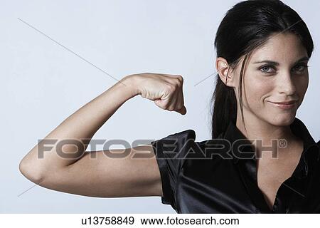 Young woman flexing muscles View Large Photo Image Stock Photo - Young woman flexing muscles. Fotosearch