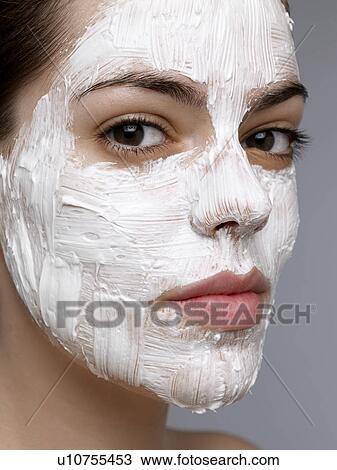 Stock Image - Young woman having face mask. Fotosearch