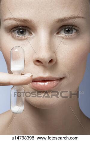 Stock Photo - Young woman holding hourglass. Fotosearch