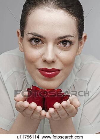 Picture - Young woman smelling red roses. Fotosearch
