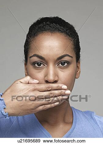 Young woman with hand over mouth View Large Photo Image Stock Photo - Young woman with hand over mouth. Fotosearch
