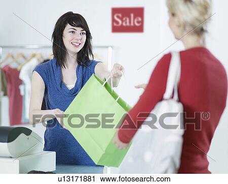 Sales Clerk Giving Shopping Bag to Customer View Large Photo Image Stock Image - Sales Clerk Giving Shopping Bag to Customer. Fotosearch