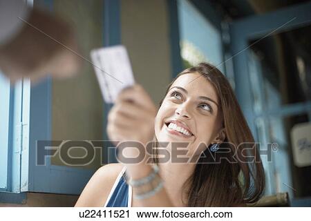 Stock Image - Woman giving credit card to man. Fotosearch