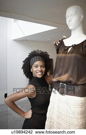 Young woman by mannequin View Large Photo Image Stock Image - Young woman by mannequin. Fotosearch