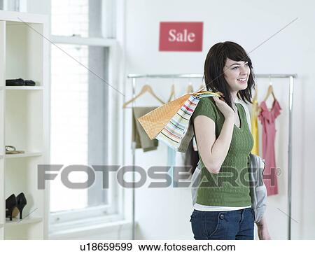 Stock Photo - Young Woman Shopping in Clothes Store. Fotosearch