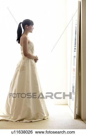 Young woman trying wedding dress on View Large Photo Image Stock Photograph - Young woman trying wedding dress on. Fotosearch