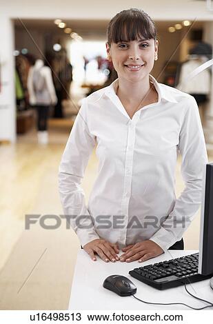 Stock Image - Sales clerk in clothing store. Fotosearch