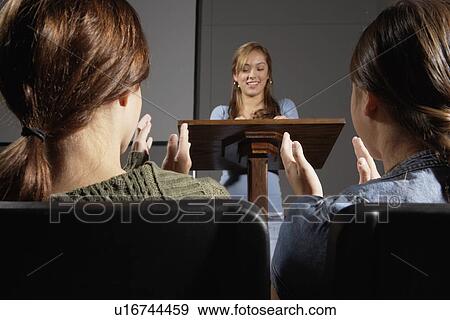 Stock Photo - Students listening to female lecturer. Fotosearch