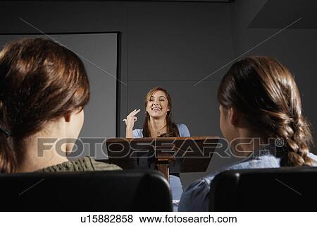 Stock Photo - Woman giving a representation to two students. Fotosearch