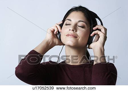 Young woman listening to headphones with eyes closed View Large Photo Image Stock Photo - Young woman listening to headphones with eyes closed. Fotosearch