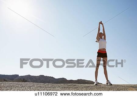 Female runner stretching (low angle view) View Large Photo Image Stock Image - Female runner stretching (low angle view). Fotosearch