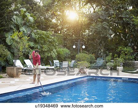 Stock Photo - Man cleaning swimming pool. Fotosearch