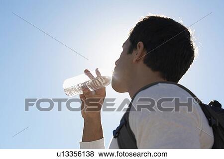 Stock Photo - Man drinking water (low angle view). Fotosearch
