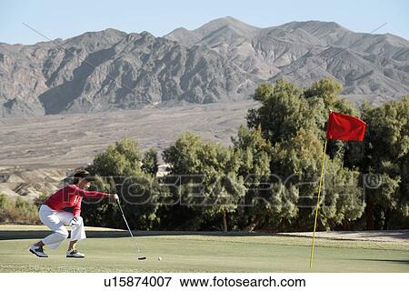 Stock Photo - Woman lining up putt. Fotosearch