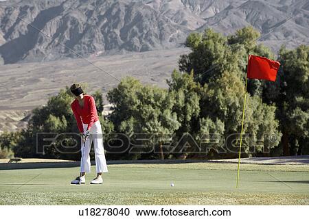 Stock Image - Woman playing golf. Fotosearch