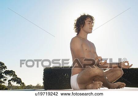 Young man in lotus position View Large Photo Image Stock Image - Young man in lotus position. Fotosearch