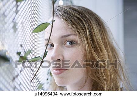 Young woman by window (portrait) View Large Photo Image Picture - Young woman by window (portrait). Fotosearch