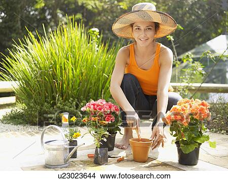 Young woman planting flowers (portrait) View Large Photo Image Picture - Young woman planting flowers (portrait). Fotosearch