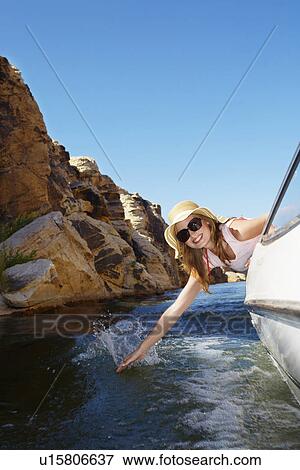 Young woman touching water from motorboat View Large Photo Image Stock Photo - Young woman touching water from motorboat. Fotosearch
