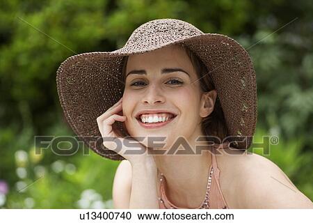 Stock Image - Young woman wearing hat. Fotosearch