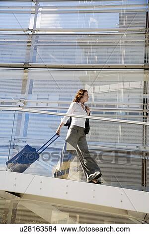 Picture - Businessman Pulling Suitcase on Ramp. Fotosearch