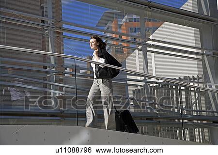 Stock Photograph - Businessman Pulling Suitcase on Ramp. Fotosearch