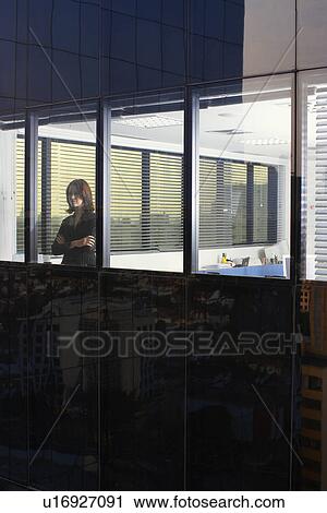 Businesswoman looking through office window (exterior view) View Large Photo Image Stock Image - Businesswoman looking through office window (exterior view). Fotosearch