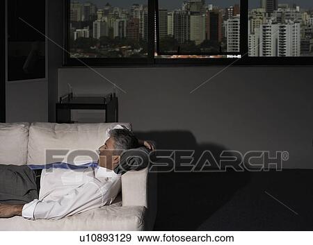 Stock Photo - Mature Businessman Sleeping on Couch in Office. Fotosearch