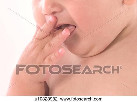 Stock Image - Close-Up, Human Face, Finger In Mouth, About Babies. Fotosearch