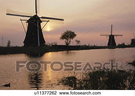 Stock Image - The Morning Sun And A Windmill. Fotosearch
