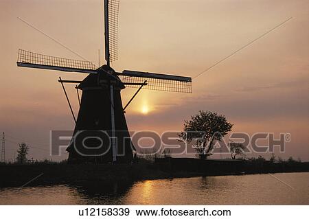 Stock Photo - The Morning Sun And A Windmill. Fotosearch