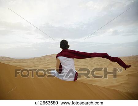 Stock Image - Woman Looking at Mountains at Sunset. Fotosearch