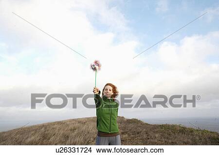 Picture - Young woman holding pinwheel. Fotosearch