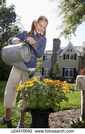 Girl (10-11) watering flowers, Chatham, New Jersey, USA View Large Photo Image Stock Image - Girl (10-11) watering flowers, Chatham, New Jersey, USA. Fotosearch
