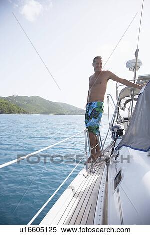 Stock Photography - Mid adult man on sailboat, St. John, US Virgin Islands, USA. Fotosearch