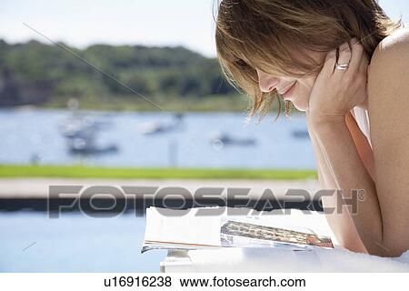Woman reading by pool View Large Photo Image Stock Photo - Woman reading by pool. Fotosearch