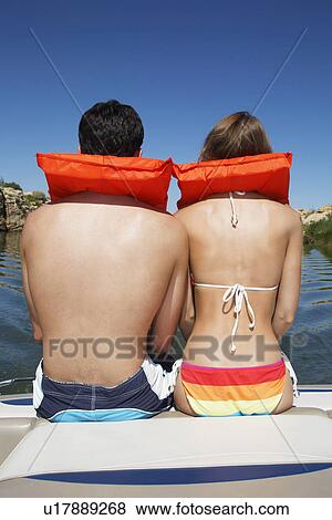 Young couple in life jackets looking at view (rear view) View Large Photo Image Stock Photo - Young couple in life jackets looking at view (rear view). Fotosearch
