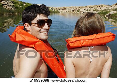 Young couple sailing in life jackets (rear view) View Large Photo Image Stock Photo - Young couple sailing in life jackets (rear view). Fotosearch