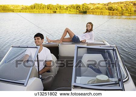 Stock Image - Young couple sailing with motorboat. Fotosearch
