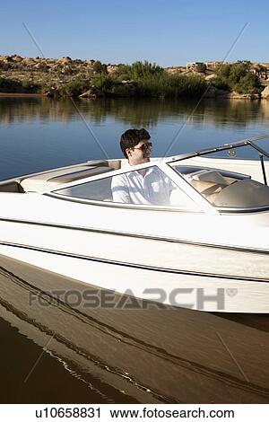 Young man in motorboat View Large Photo Image Stock Image - Young man in motorboat. Fotosearch