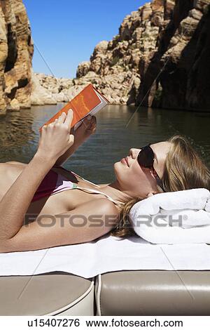 Young woman reading book in motorboat View Large Photo Image Stock Photograph - Young woman reading book in motorboat. Fotosearch