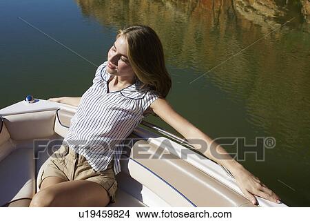 Young woman relaxing in boat (high angle view) View Large Photo Image Picture - Young woman relaxing in boat (high angle view). Fotosearch