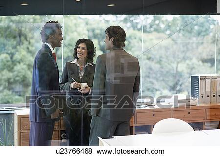 Stock Photo - Businesspeople talking in office. Fotosearch