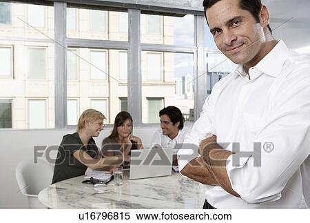 Male manager, colleagues using laptop in background (portrait) View Large Photo Image Stock Photography - Male manager, colleagues using laptop in background (portrait). Fotosearch
